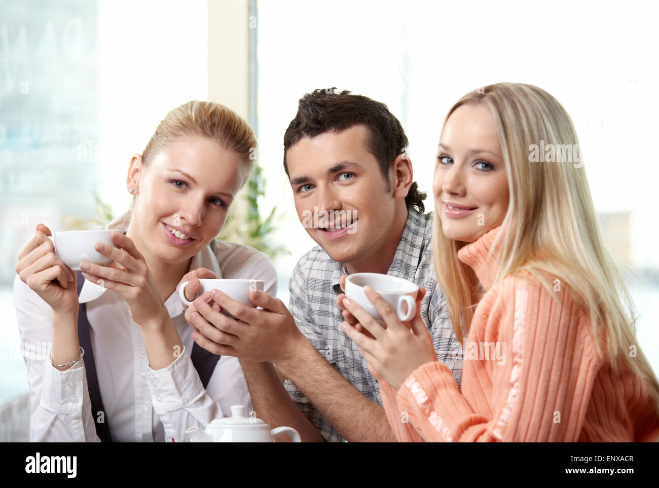 Nice young people drink coffee on a forward background Stock Photo