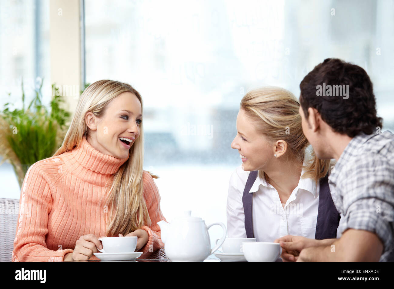 Smiling people drink coffee in the foreground Stock Photo