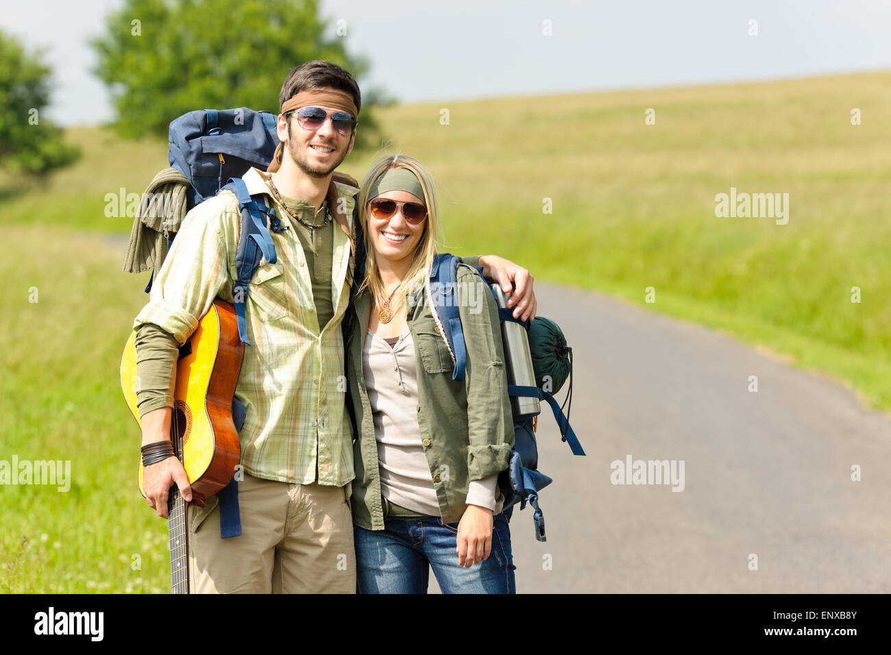 Hiking young couple backpack tramping asphalt road Stock Photo Alamy