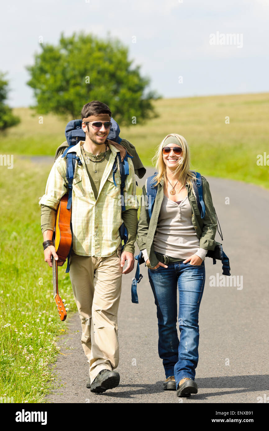 Hiking young couple backpack tramping asphalt road Stock Photo Alamy