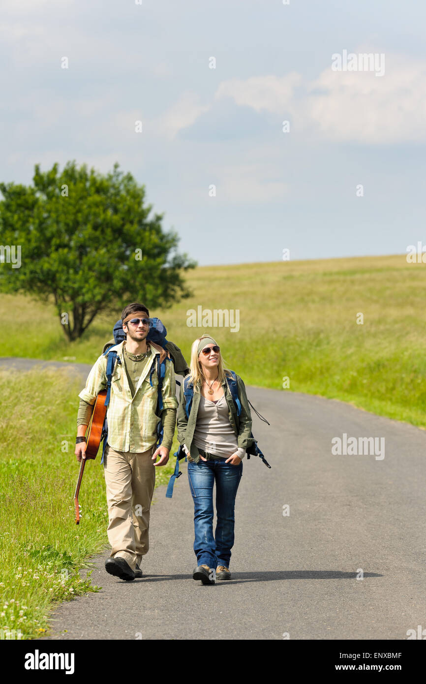 Hiking young couple backpack tramping asphalt road Stock Photo Alamy