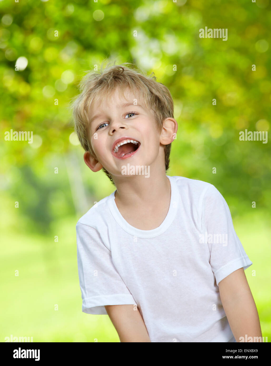 Portrait of the laughing loudly boy against a summer garden Stock Photo