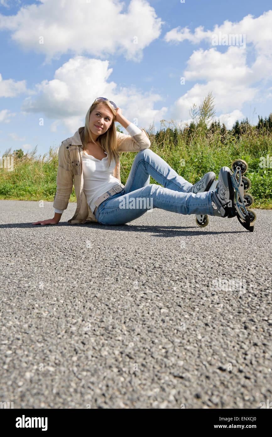 Inline skates young woman sitting asphalt road Stock Photo Alamy