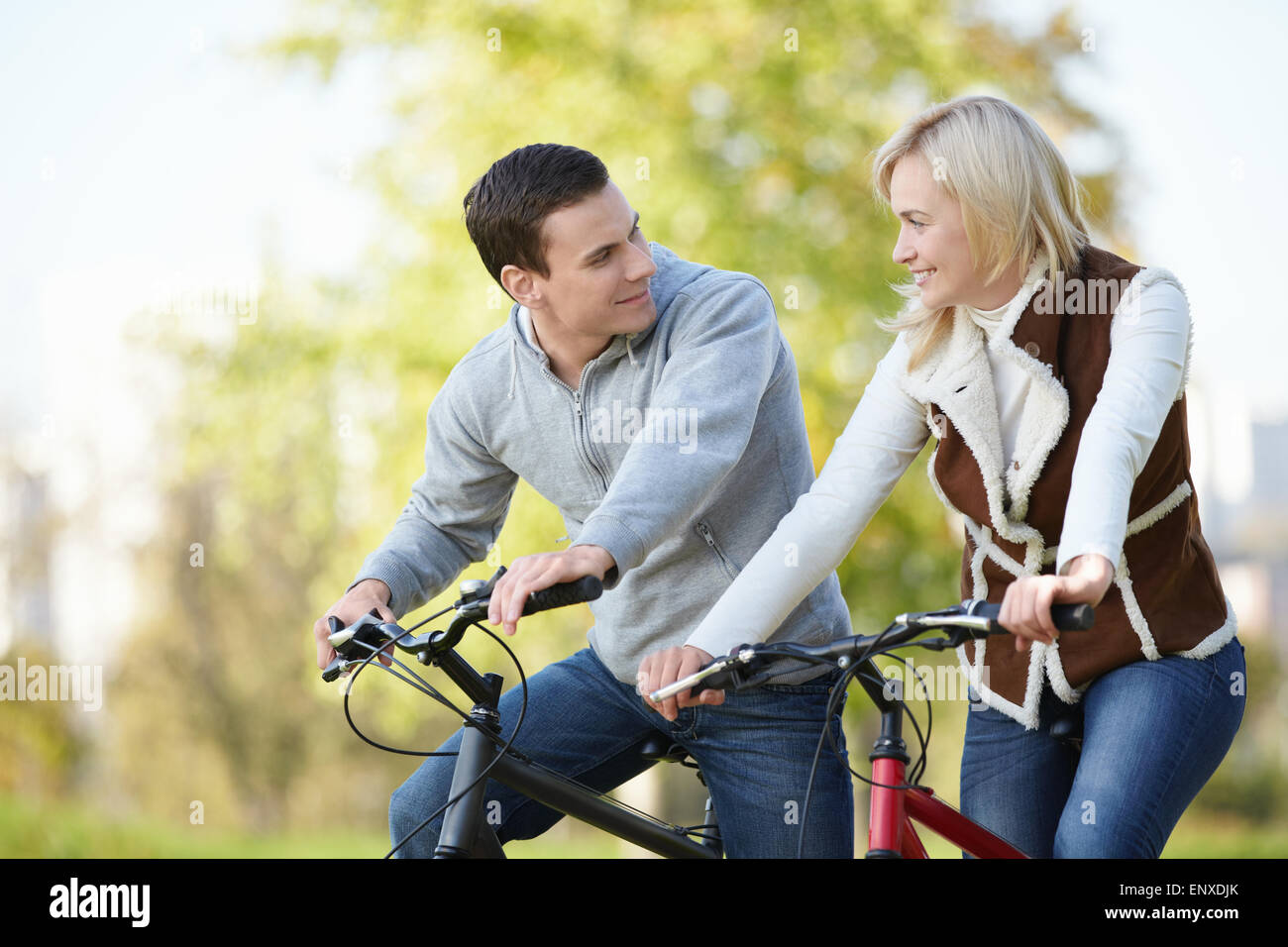 Attractive couple on bicycles looking at each other Stock Photo