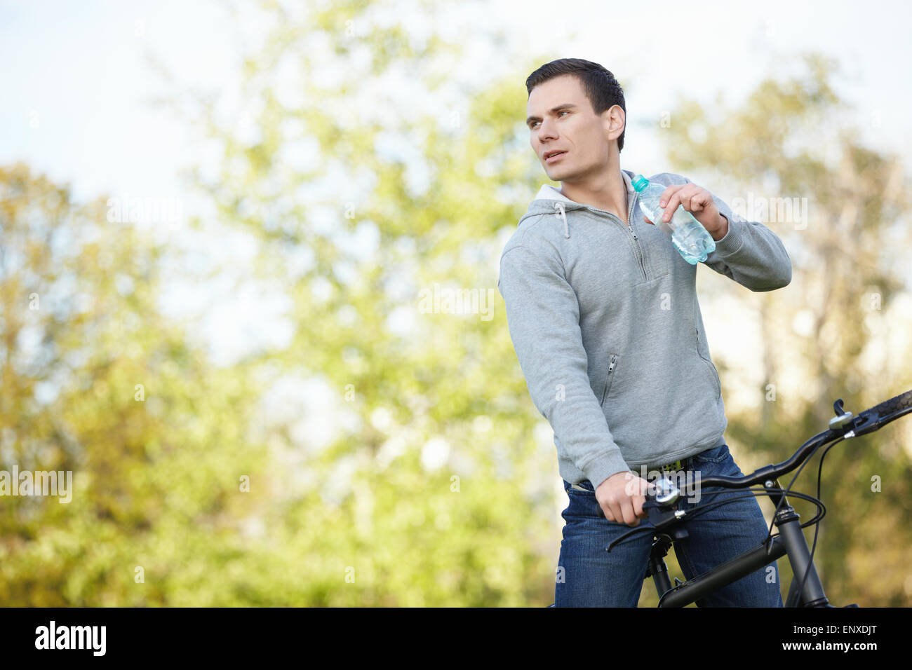 Young attractive man on a bicycle drink water Stock Photo