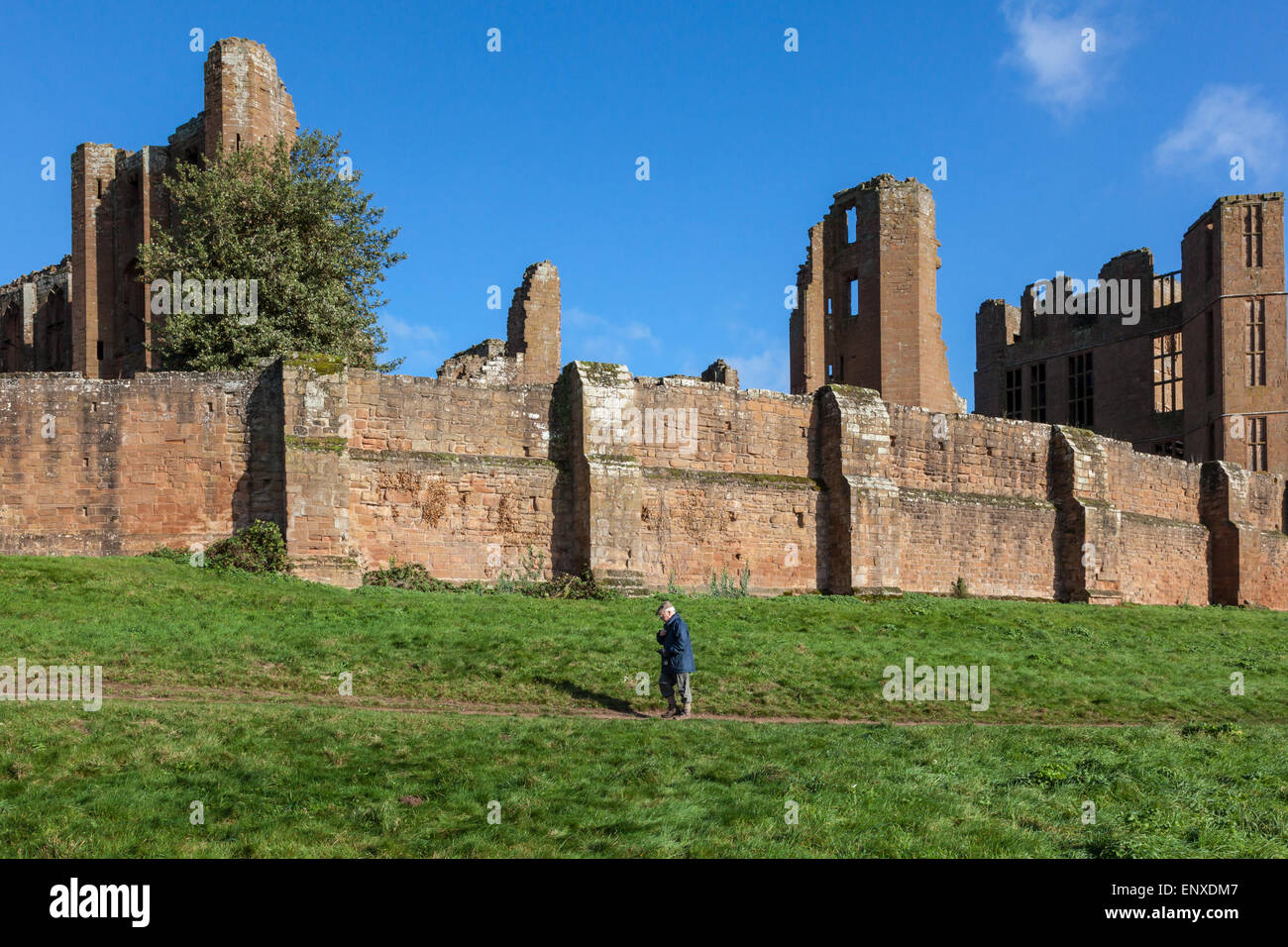 A man walks the circular path around Kenilworth Castle and outer walls