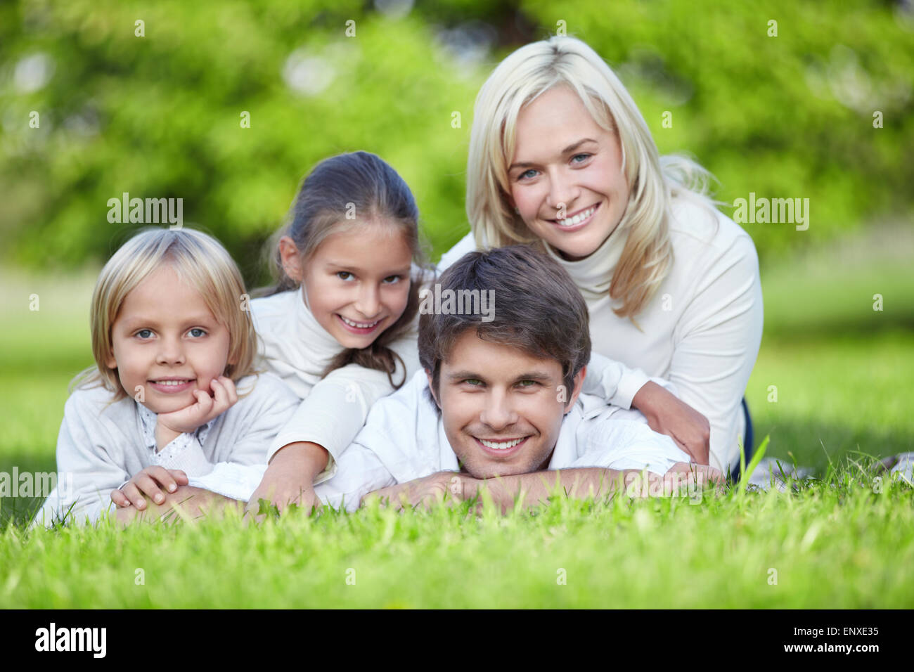 A happy family lying on the grass in the park Stock Photo - Alamy