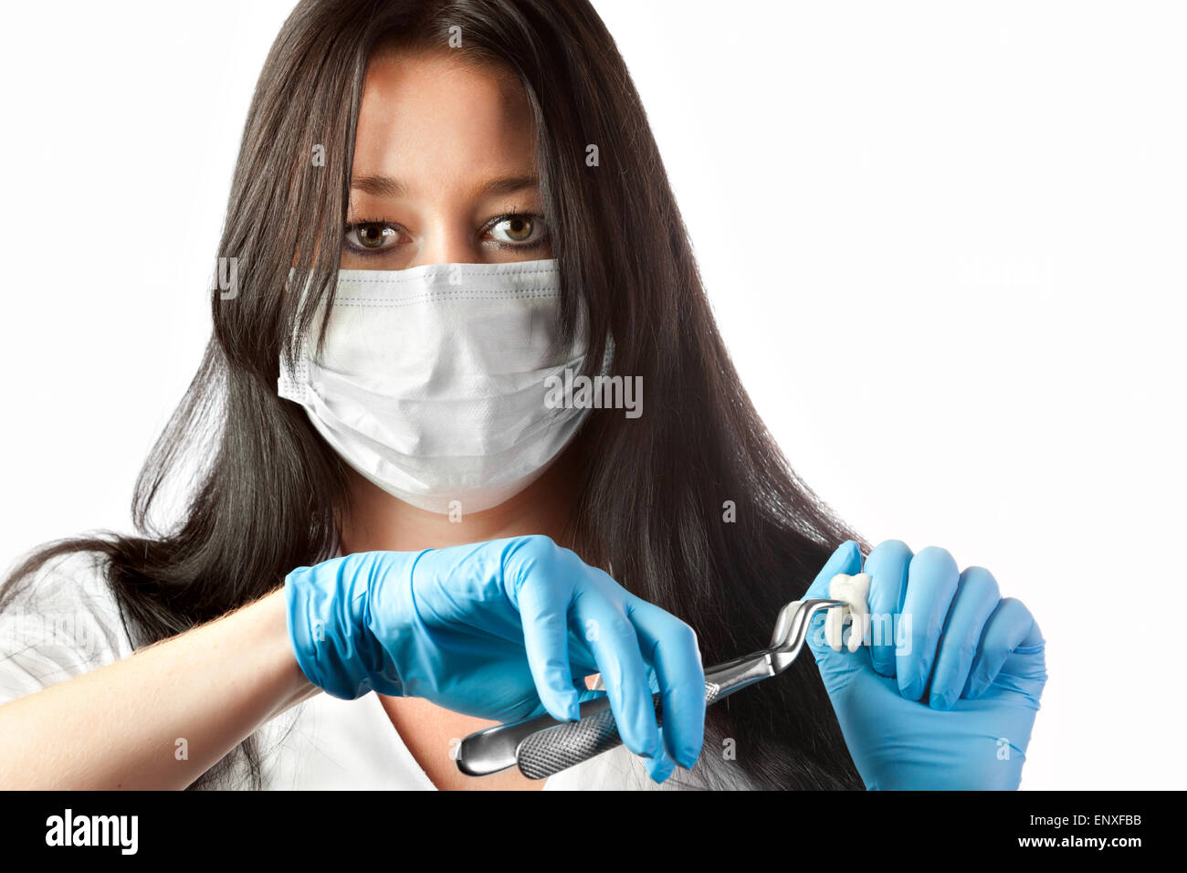 female dentist in mask holding forceps and tooth Stock Photo Alamy