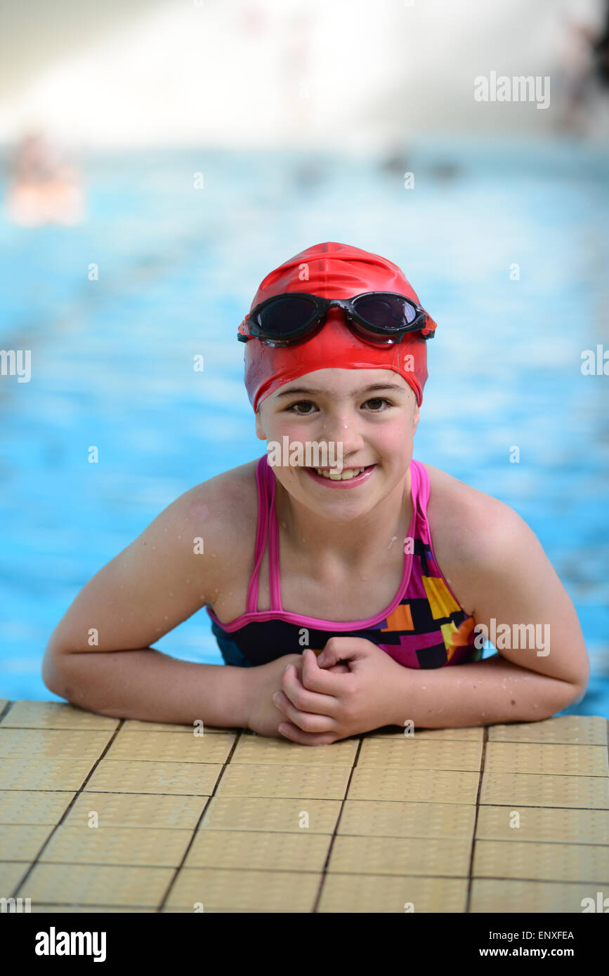 A young girl swimmer climbing out of a swimming pool. Picture Scott