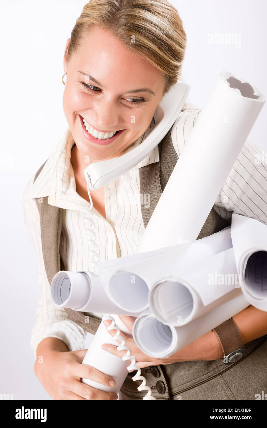 Young female engineer on phone carry blueprints Stock Photo