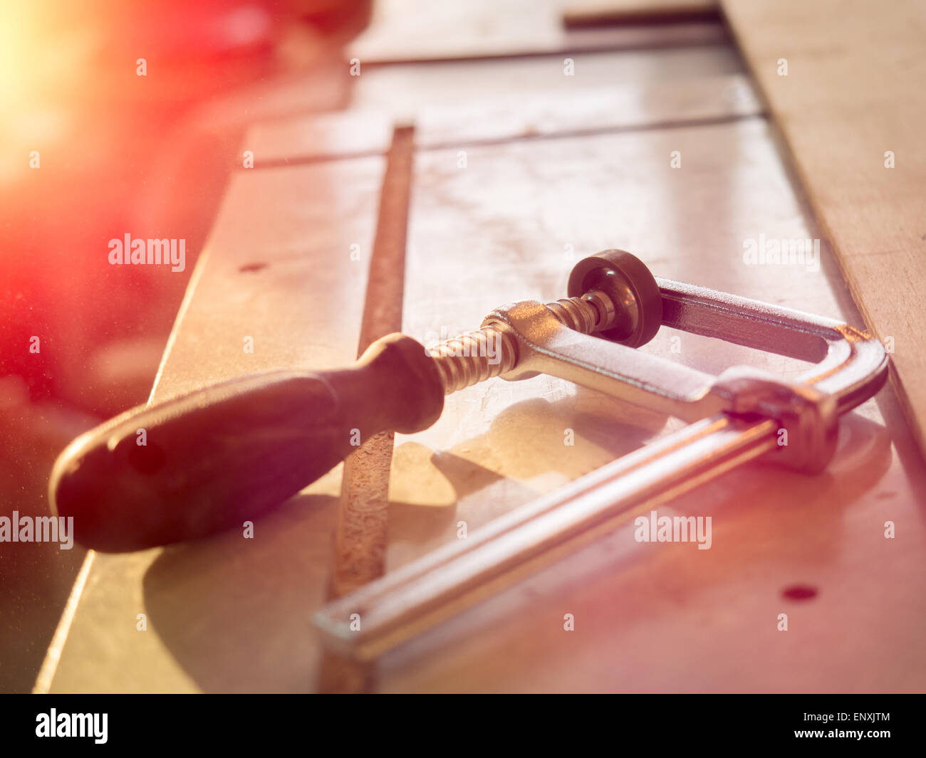 Real woodworking shop: clamps holding workpiece gluing, close-up Stock Photo
