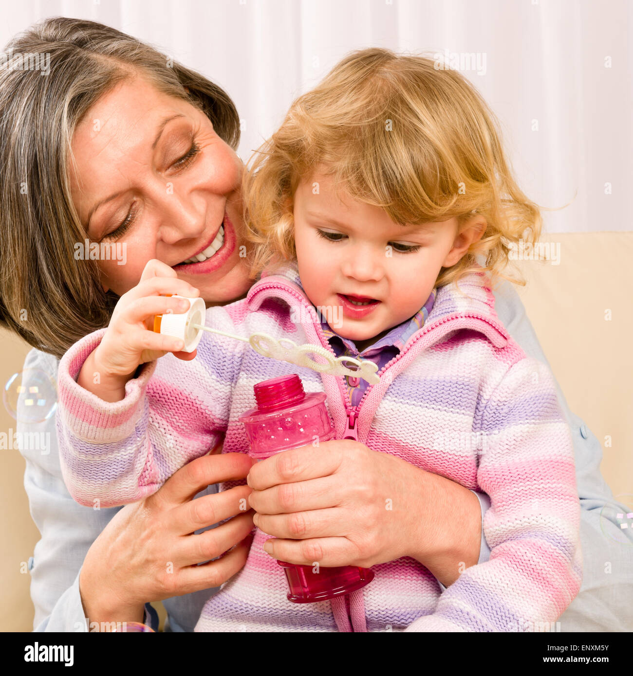 Little girl with grandmother play bubble blower Stock Photo - Alamy