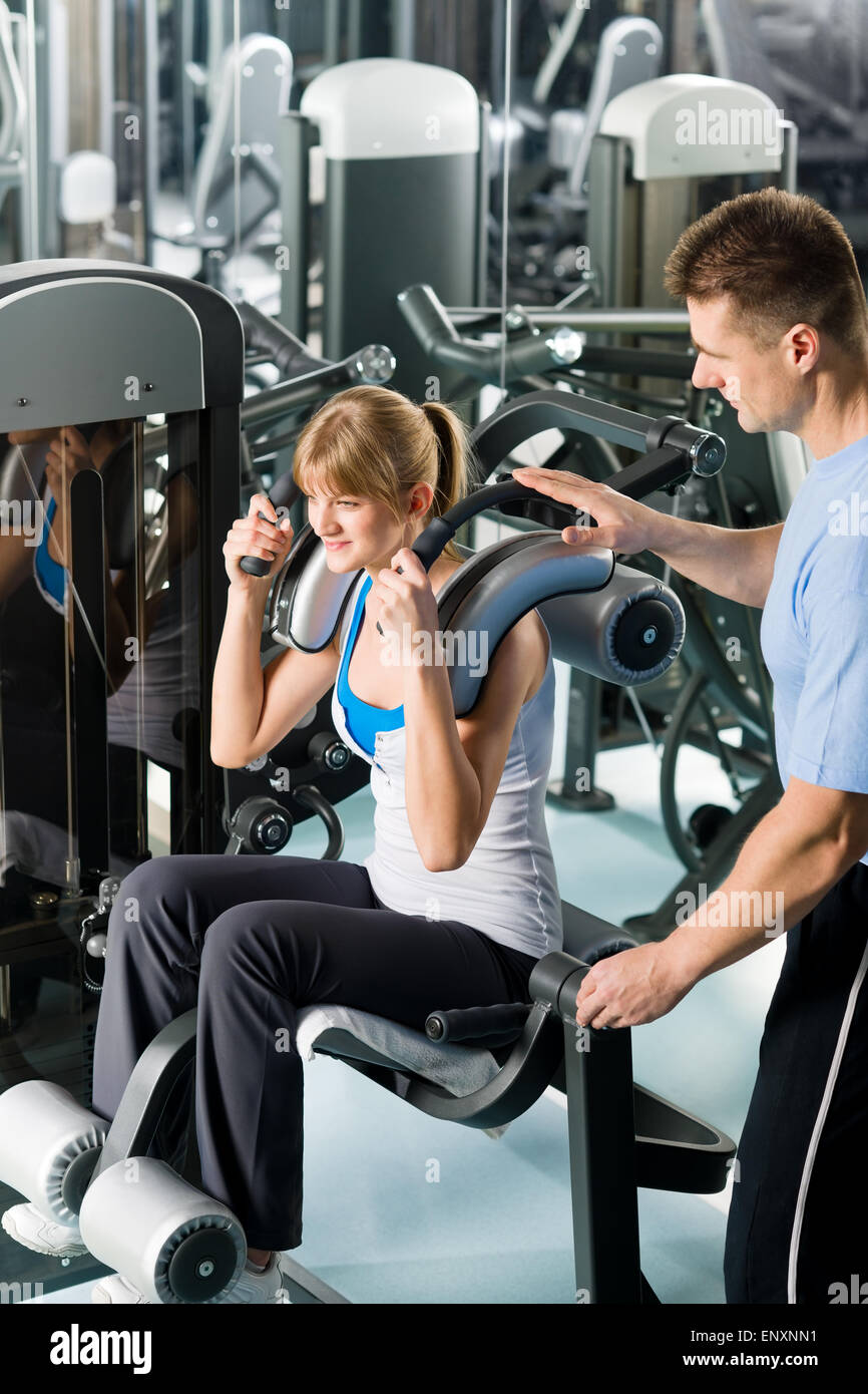 Fitness center young woman exercise with trainer Stock Photo - Alamy