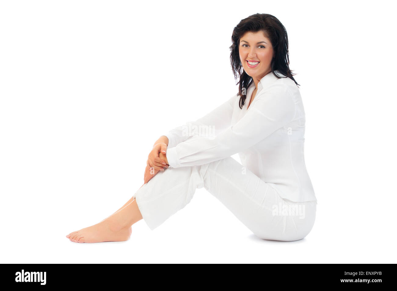 Young smiling woman sitting on floor isolated Stock Photo - Alamy
