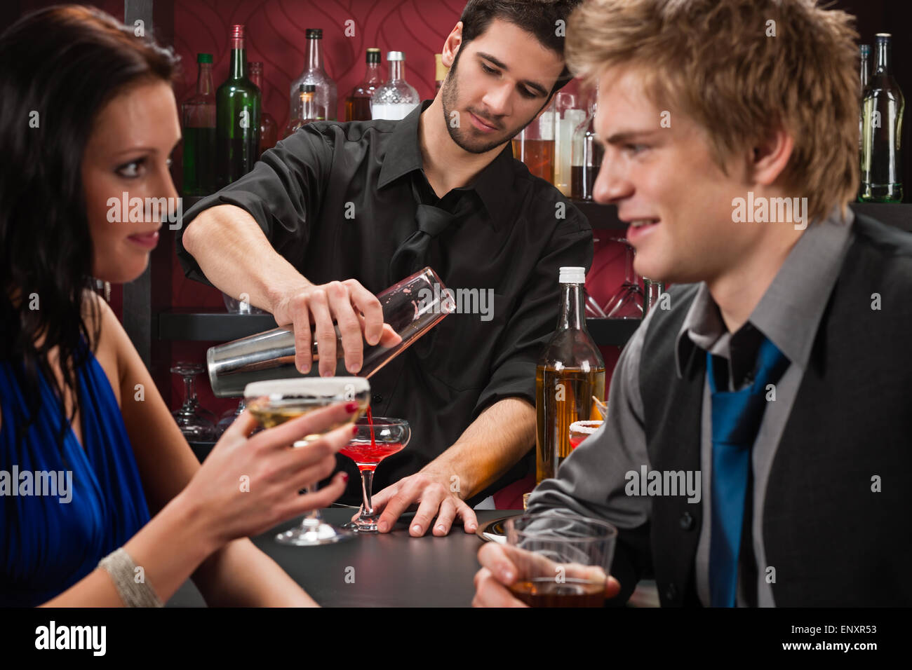 Bartender shaking cocktail friends having drink Stock Photo Alamy