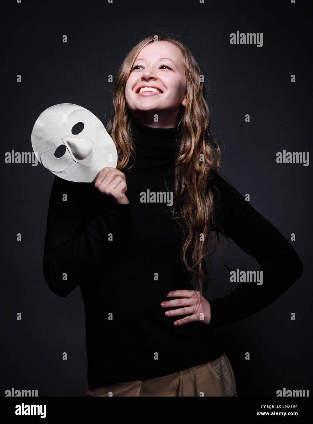 Low key portrait of a beautiful woman holding mask Stock Photo Alamy