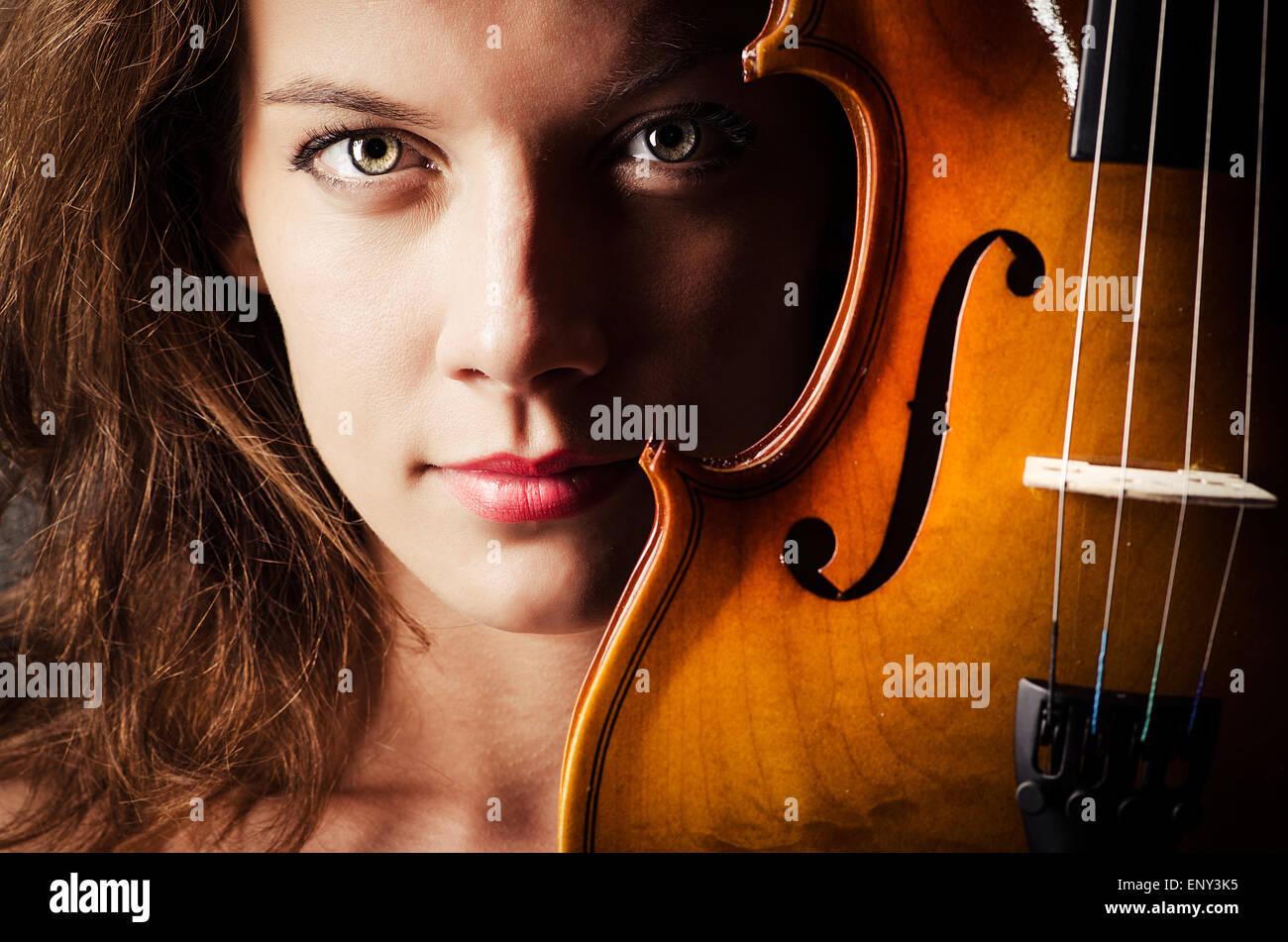 Woman with violin in dark room Stock Photo - Alamy