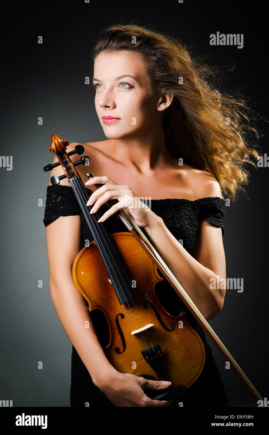 Woman with violin in dark room Stock Photo - Alamy
