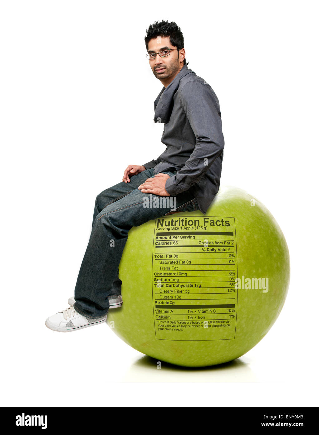 Man Sitting on Red Delicious Apple with Nutrition Label Stock Photo