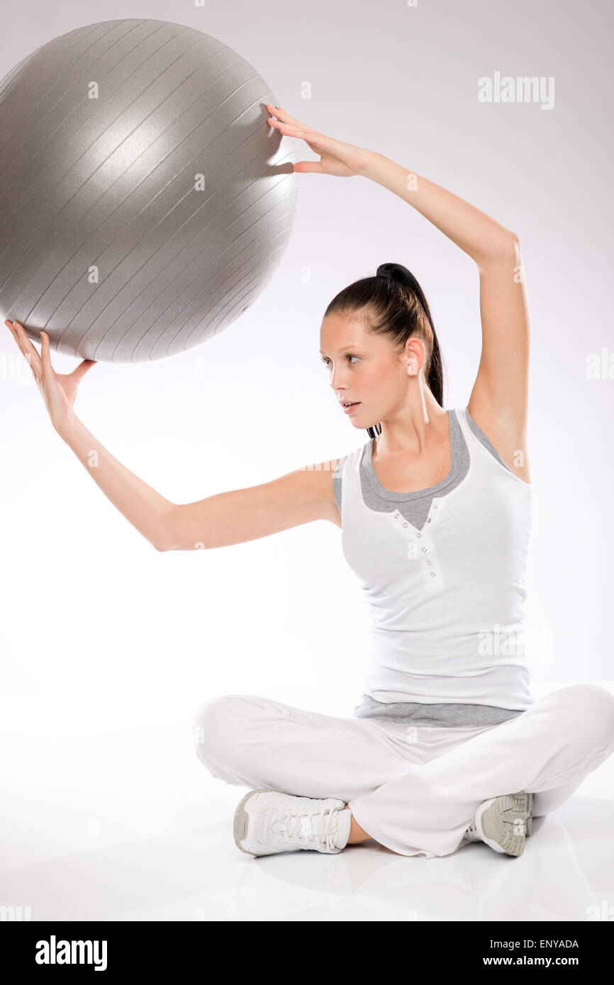 Slim young woman exercising from sitting position Stock Photo