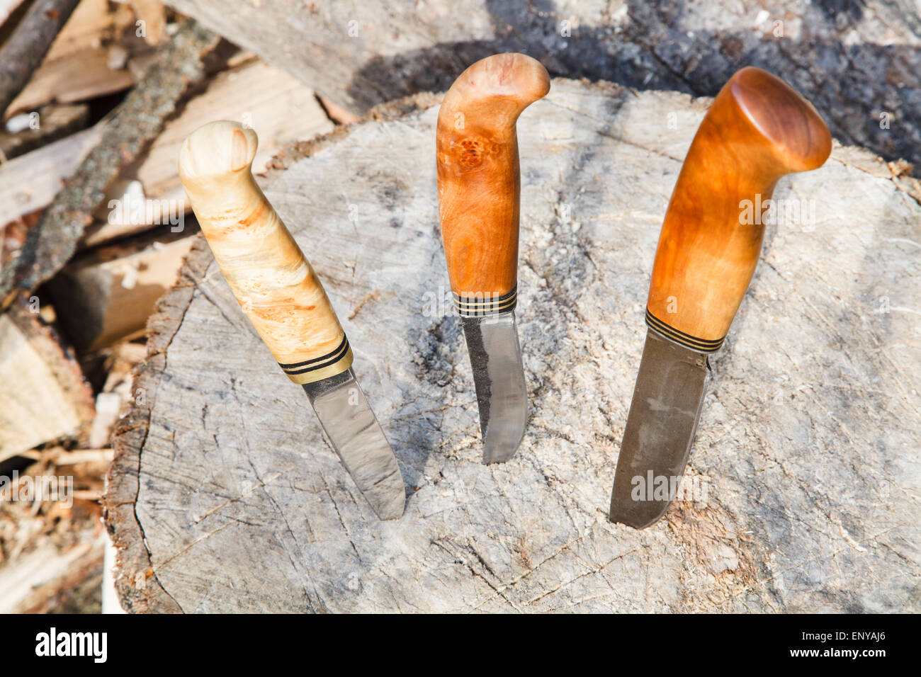 three hunting knives thrust in tree stump Stock Photo Alamy