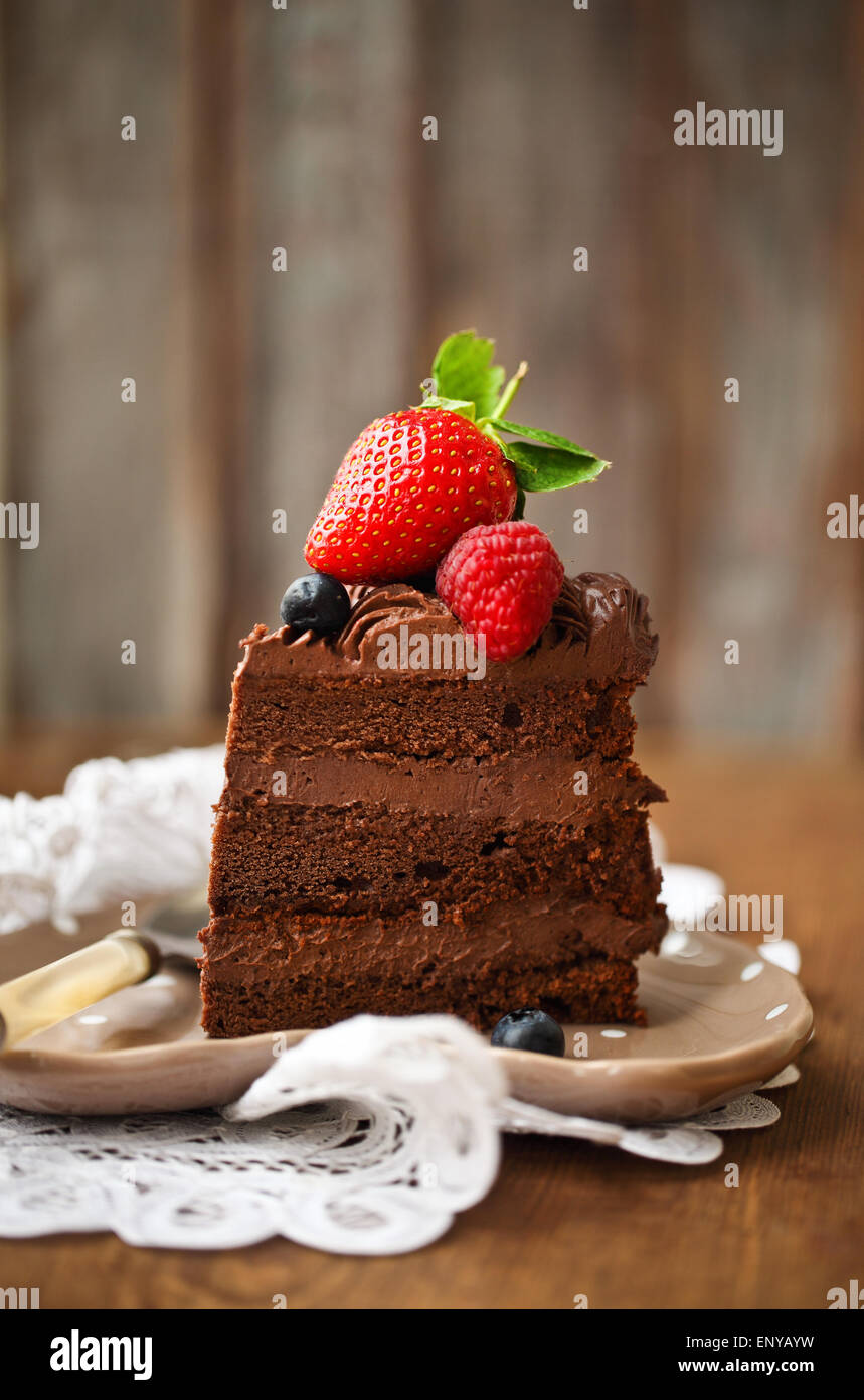 Piece of chocolate cake with icing and fresh berry Stock Photo - Alamy