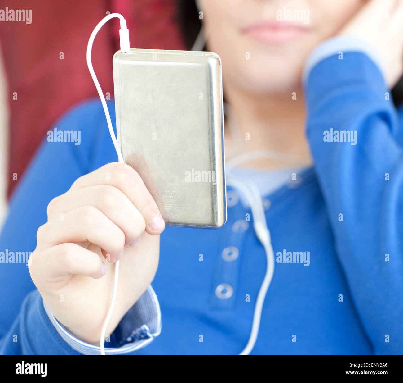 Close-up of a brunette teen girl listening music lying on a sofa Stock ...