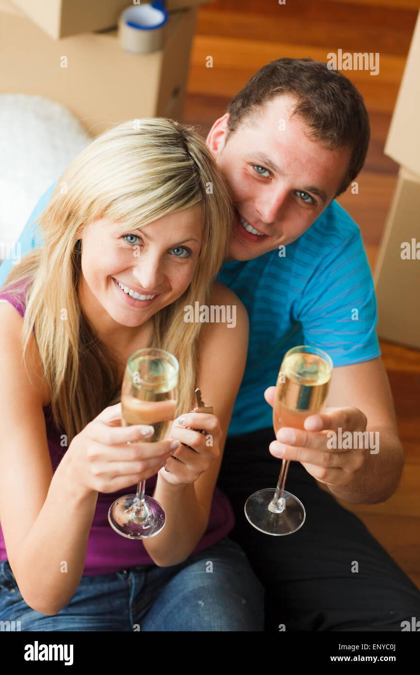 High angle of a happy couple celebrating new house with champagne ...