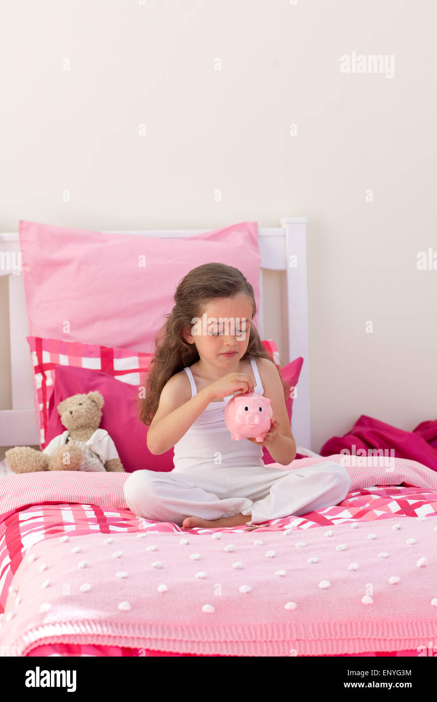 High angle of a little girl saving money in a piggybank Stock Photo - Alamy