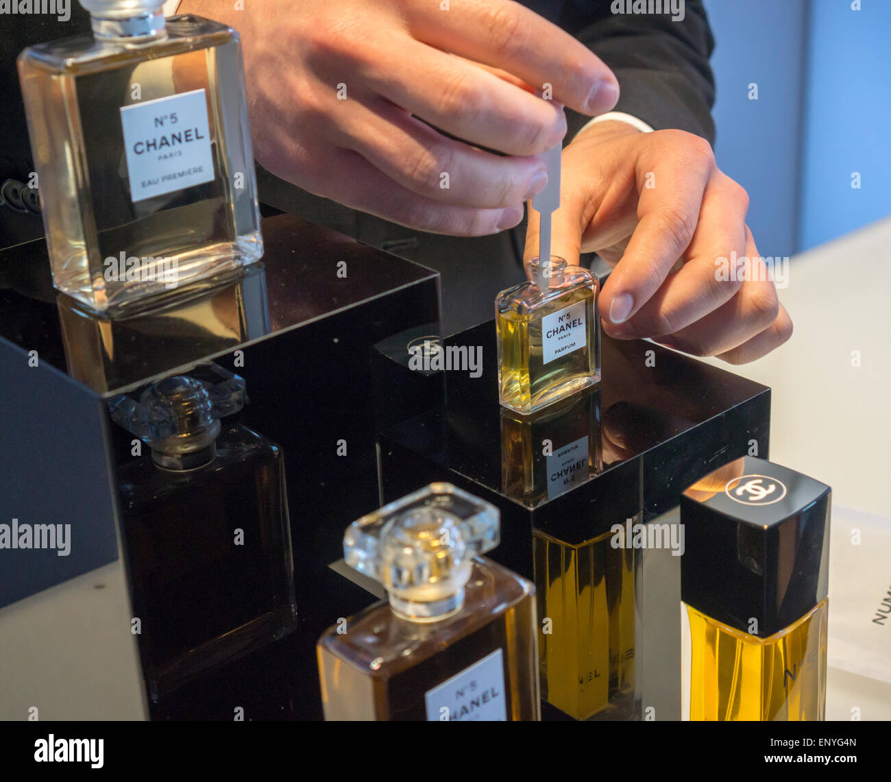 A host dispenses samples of the original Chanel No.5 perfume at a branding event in New York in the Meatpacking District on Friday, May 8, 2015. Participants got to use interactive exhibits explaining the history of the perfume, created in 1921, and the introduction of a new lighter version of the classic No. 5, Eau Premiére. (© Richard B. Levine) Stock Photo