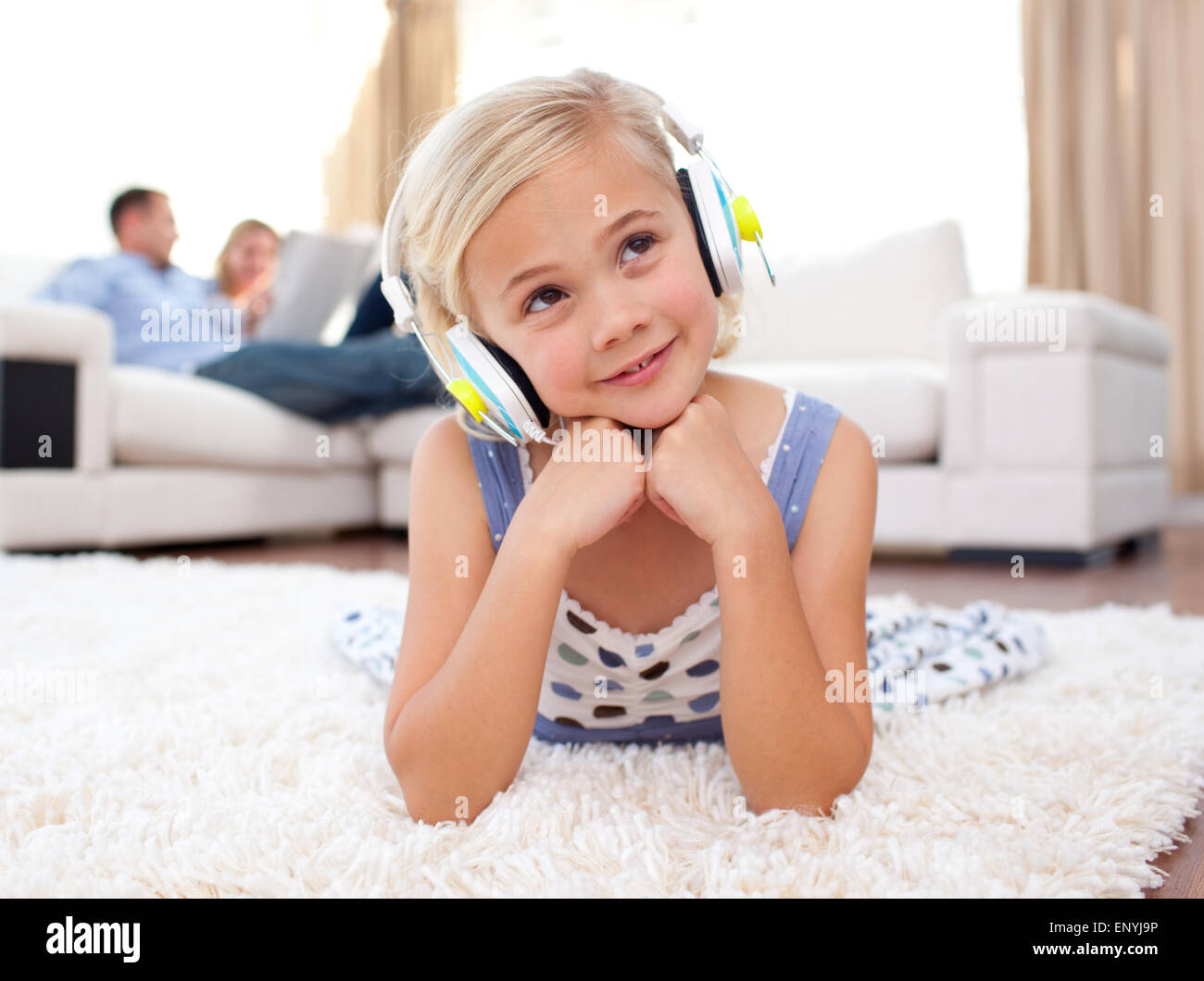 Adorable little girl listening music lying on the floor Stock Photo - Alamy