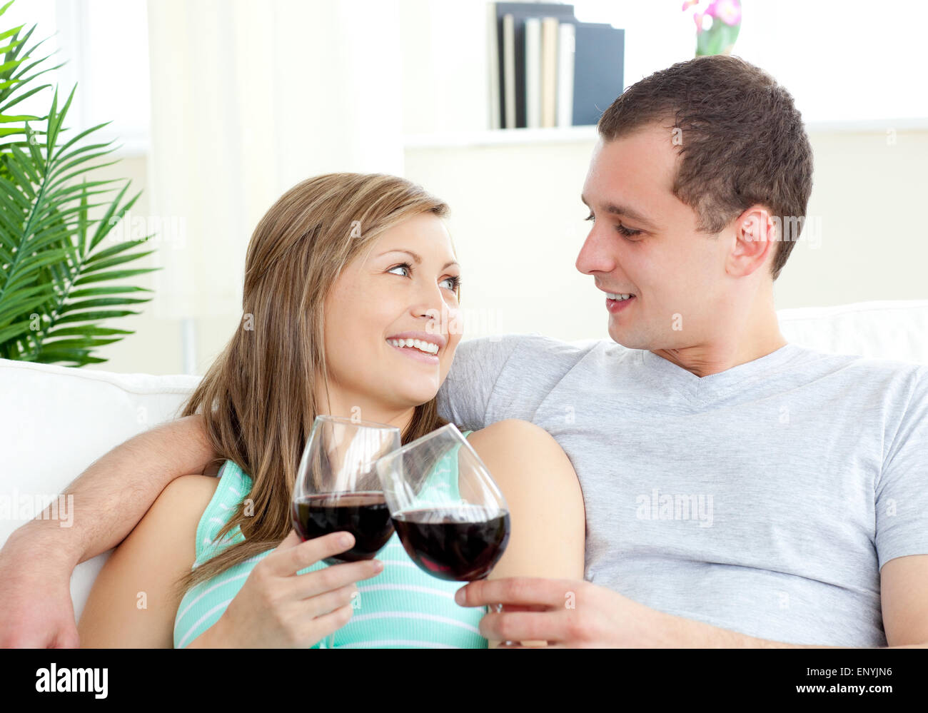 Portrait of a loving young couple drinking red wine Stock Photo - Alamy