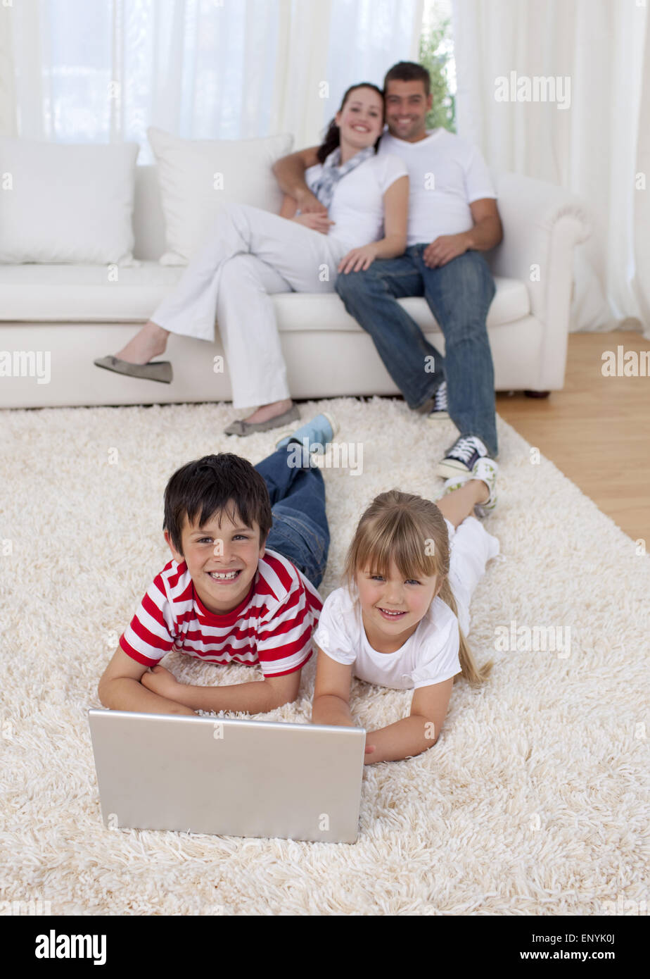 Children using a laptop on floor in living-room Stock Photo - Alamy