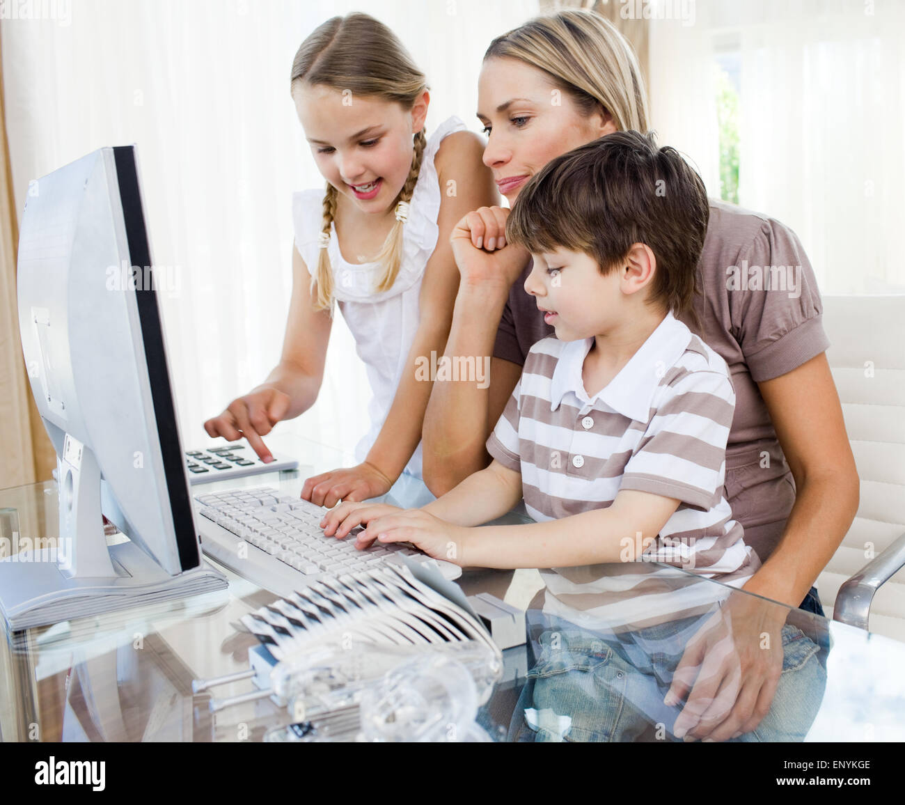 Attentive mother teaching her children how to use a computer Stock ...