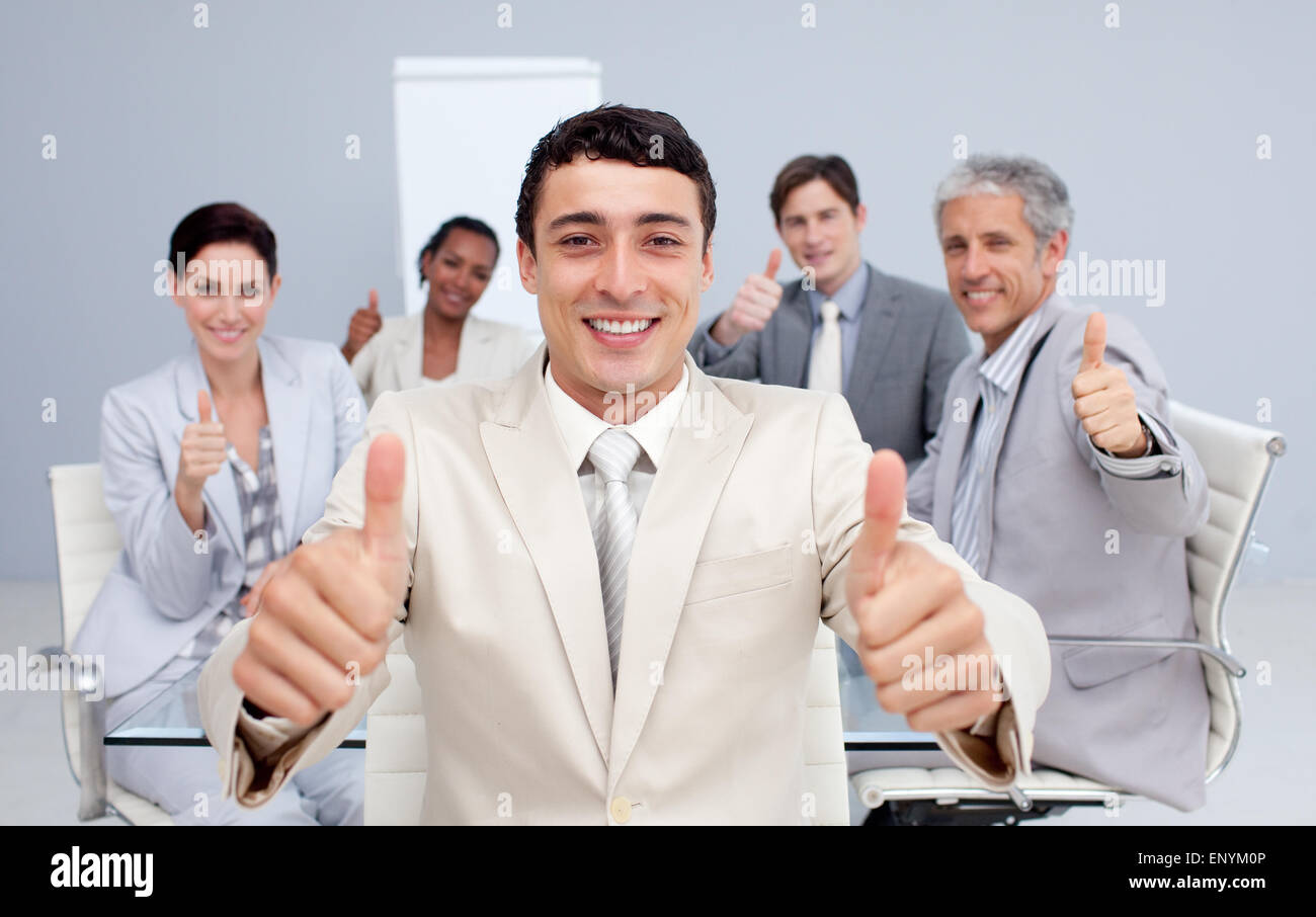 Attractive businessman and his team with thumbs up Stock Photo - Alamy