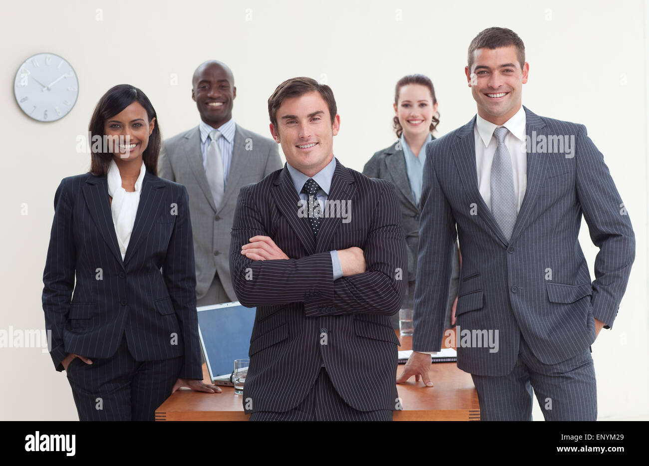 Confident business team standing in a meeting and smiling at the camera ...