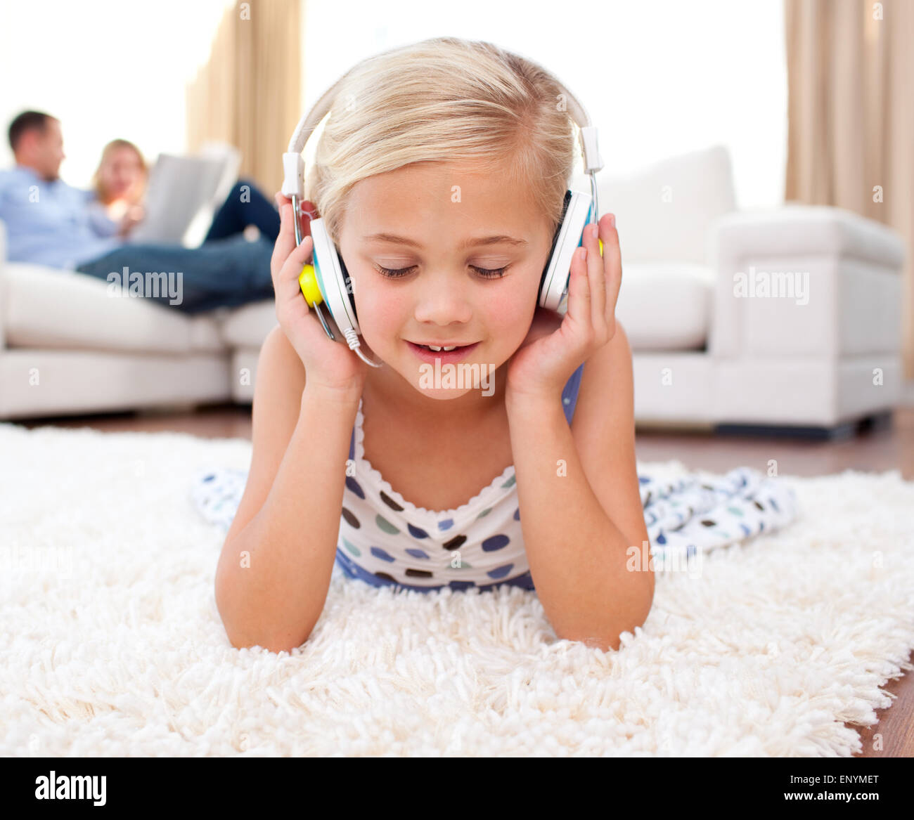 Cute little girl listening music lying on the floor Stock Photo - Alamy