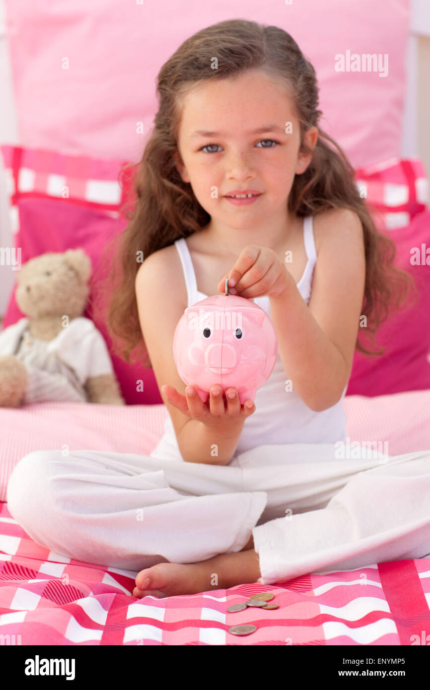Little girl saving money in a piggybank Stock Photo - Alamy