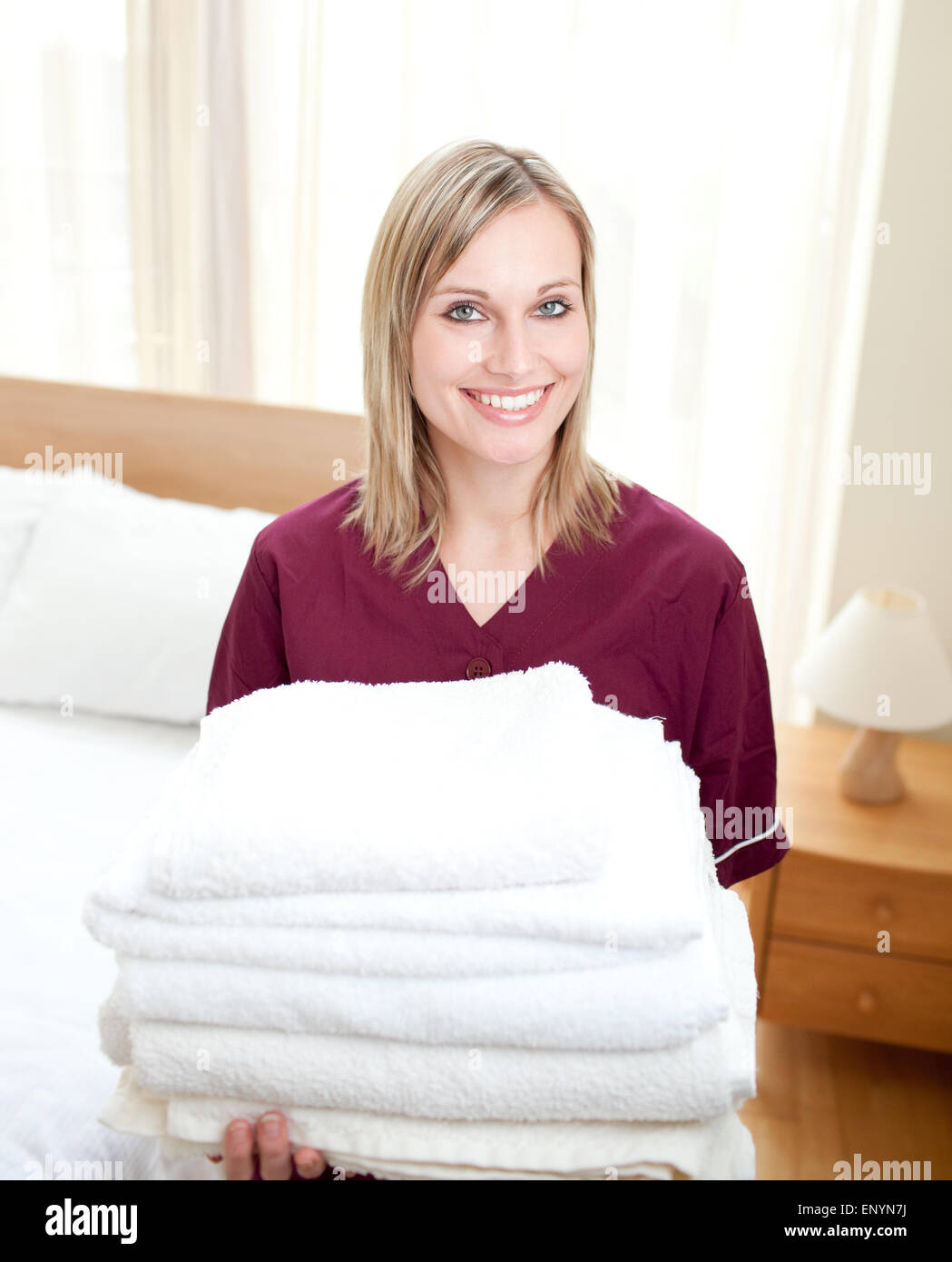 Smiing cleaning lady holding towels in a hotel room Stock Photo Alamy