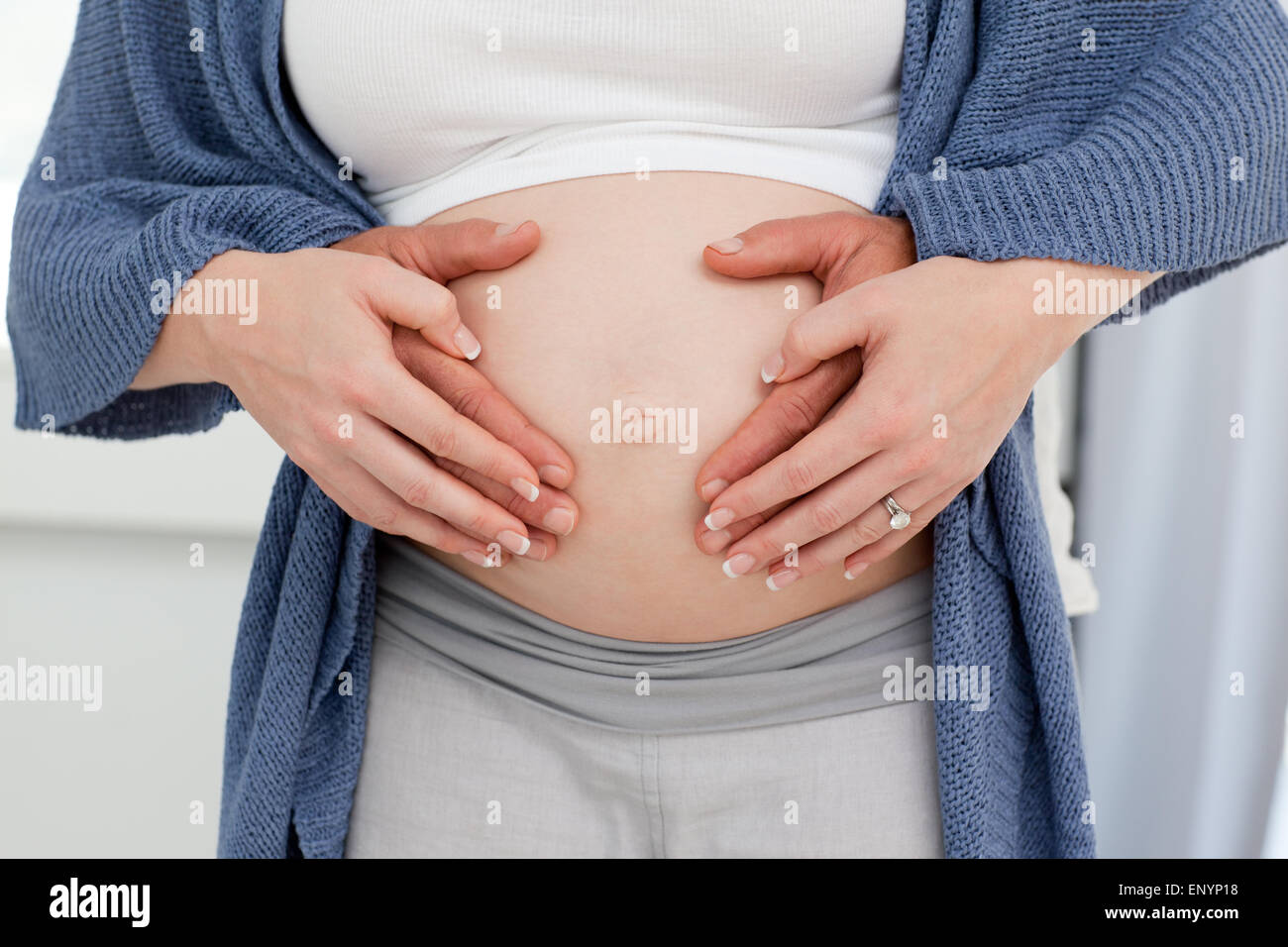 Couple's hand on the belly of the pregnant woman Stock Photo