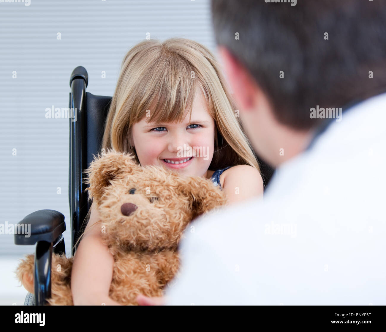 Smiling little girl sitting on the wheelchair with her teddy bear Stock ...
