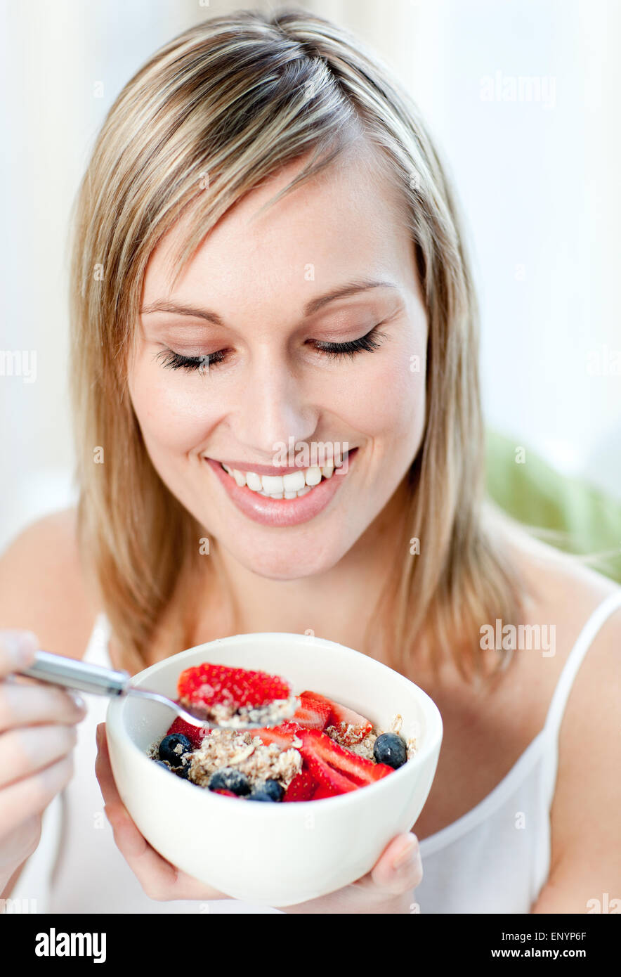 Bright woman eating muesli with fruits Stock Photo Alamy