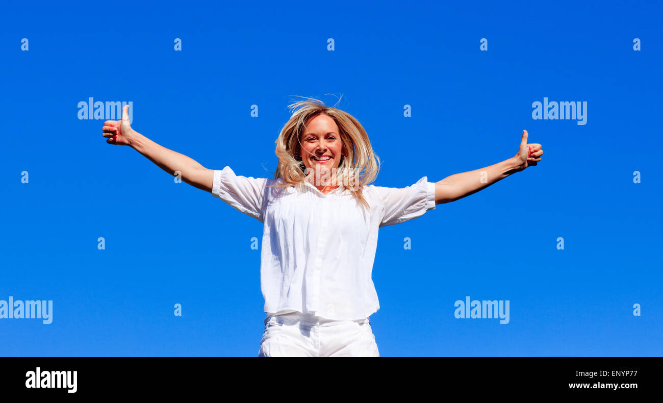 Young woman jumping against blue sky Stock Photo - Alamy