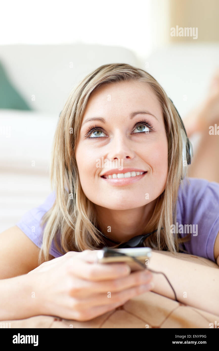 Blond woman listening music lying on the floor Stock Photo - Alamy