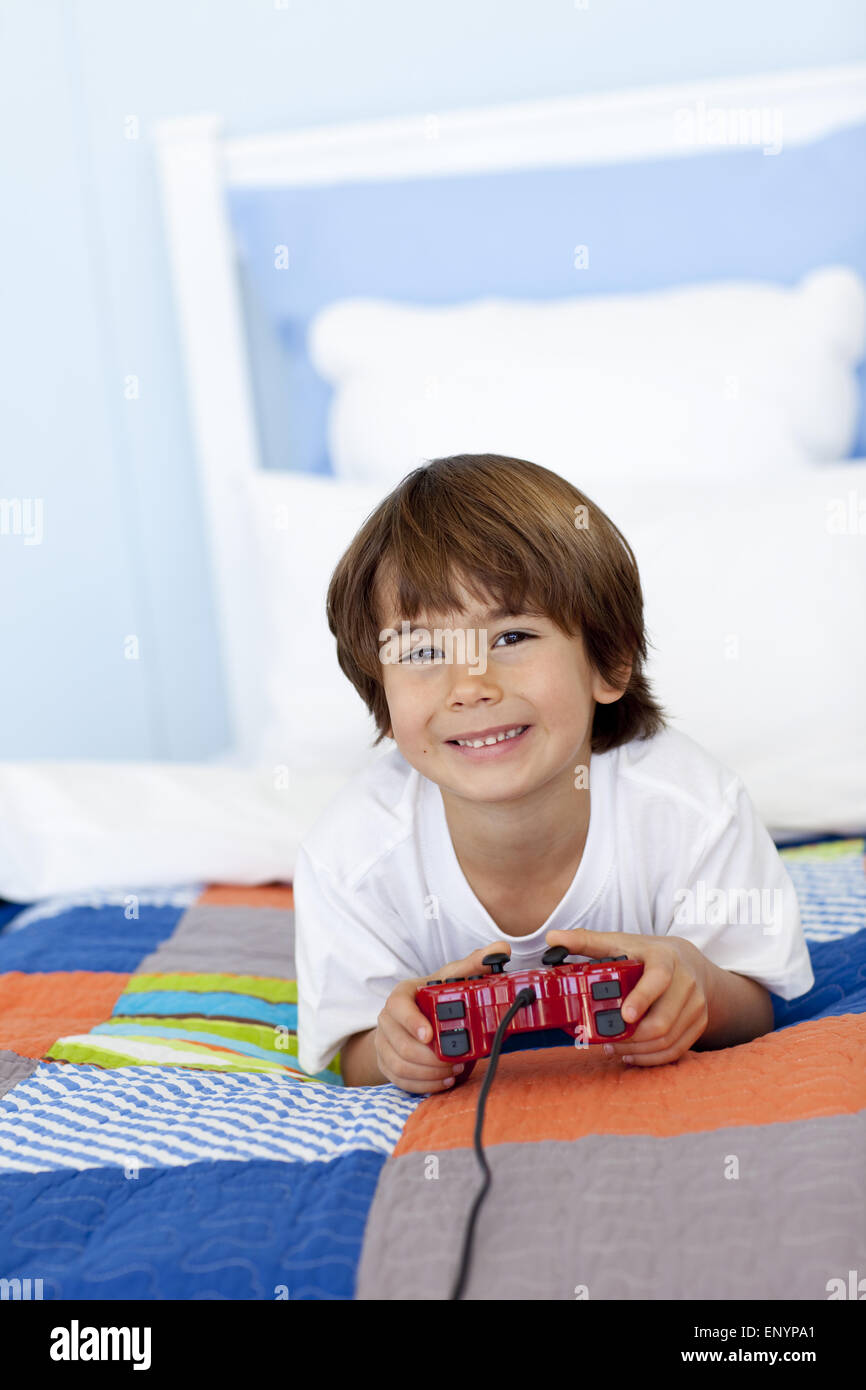 Smiling boy playing videogames in his bedroom Stock Photo Alamy
