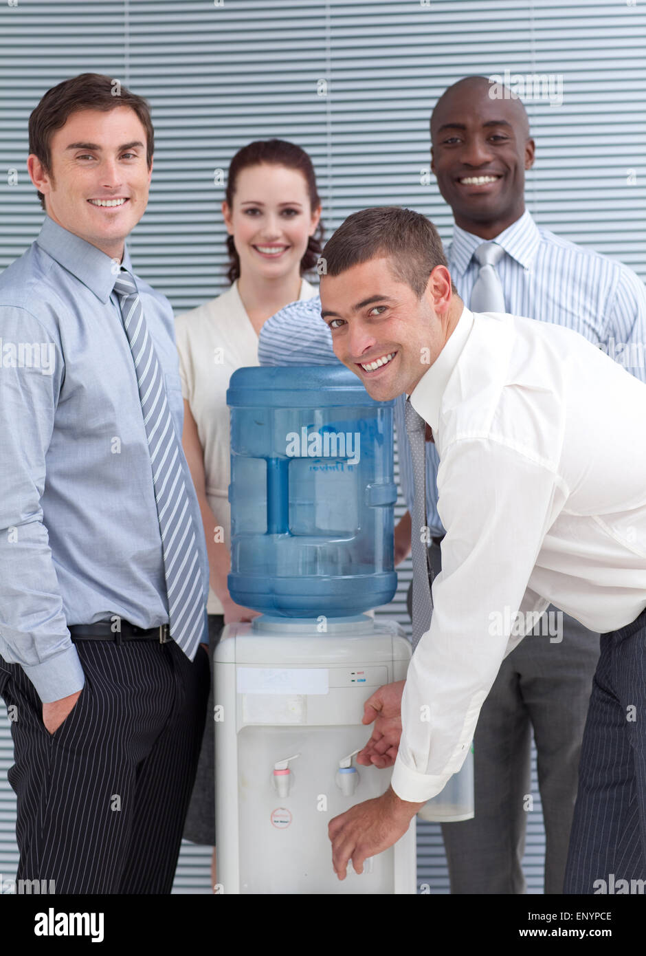 Busines people standing around water cooler in workplace Stock Photo
