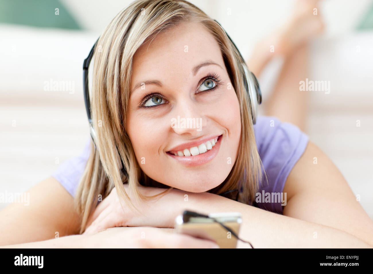 Charming woman listening music lying on the floor Stock Photo - Alamy