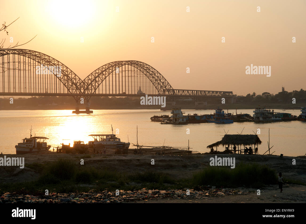 Looking across to the new metal Sagaing bridge silhouetted by the setting sun near Mandalay Myanmar Stock Photo