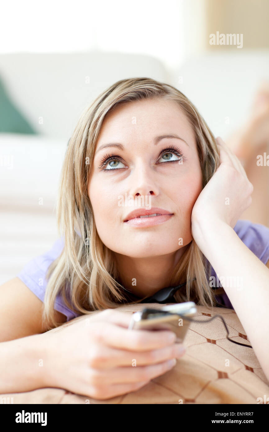 Attractive woman listening music lying on the floor Stock Photo - Alamy