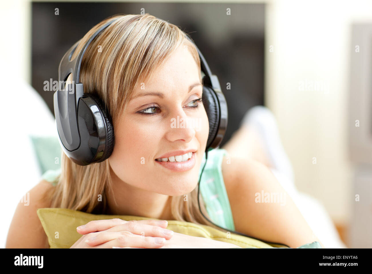 Beautful young woman listening music lying on a sofa Stock Photo - Alamy